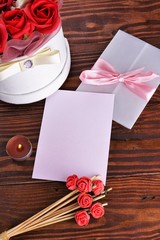 Gift box with flowers on wooden background, preparation for the holiday concept. Top view and copy area for text.
