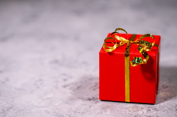 Gift, red box packed on a gray background, close-up. Holiday, New Year, Christmas. Flat lay, top view, space for text.surprise