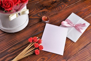 Gift box with flowers on wooden background, preparation for the holiday concept. Top view and copy area for text.