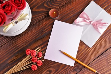 Gift box with flowers on wooden background, preparation for the holiday concept. Top view and copy area for text.
