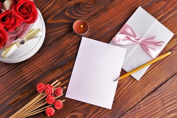Gift box with flowers on wooden background, preparation for the holiday concept. Top view and copy area for text.