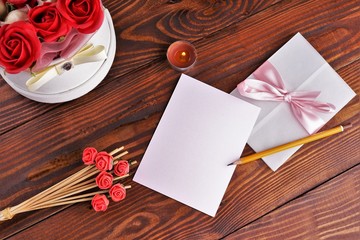 Gift box with flowers on wooden background, preparation for the holiday concept. Top view and copy area for text.