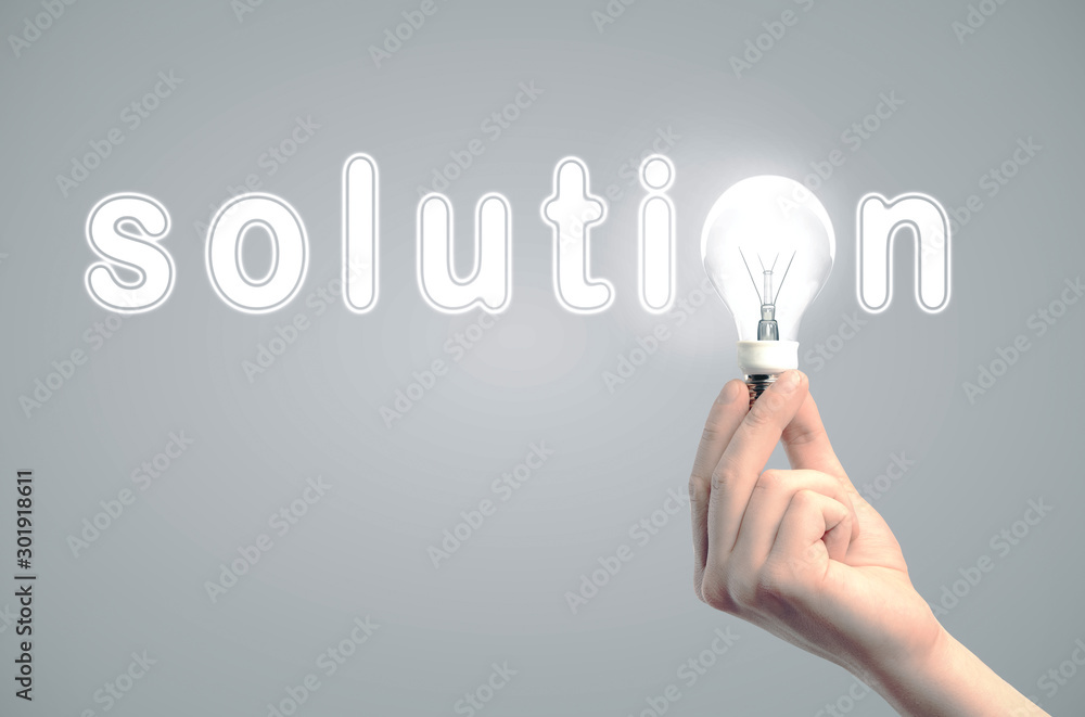 Poster hand holding light bulb in text solution