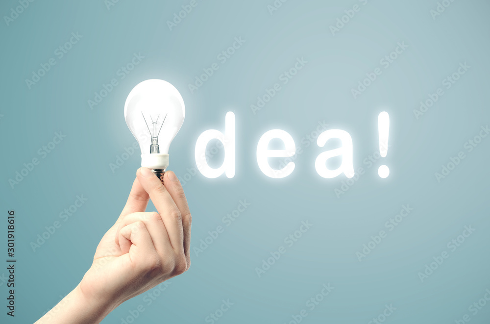 Poster hand holding light bulb in text idea