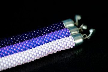 Three beaded bracelets on a dark background close up