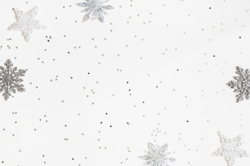 Christmas or winter composition. Frame made of silver snowflakes on white background. Christmas, winter, new year concept. Flat lay, top view, copy space