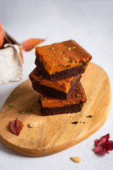 A stack of pumpkin chocolate brownies on white background, homemade bakery and dessert. Bakery, confectionery concept
