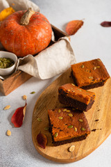 Homemade pumpkin chocolate brownie on wooden board. Copy space, top view. Confectionery, bakery, thanksgiving food concept