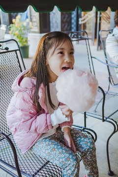 Cute Asian girl enjoying candyfloss