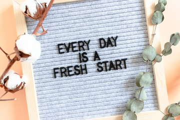 Flowers and letterboard with quote Every day is a fresh start