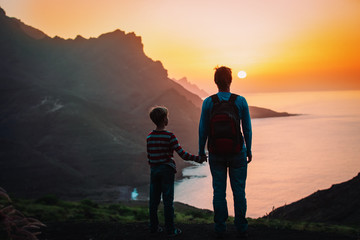 father and son travel in sunset mountains, family travel