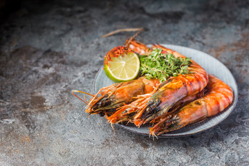 Giant fresh Tiger Prawns on plate over dark stone background
