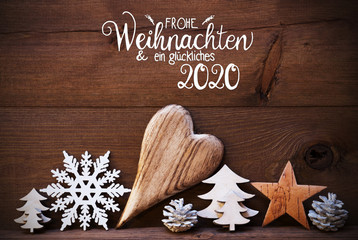 German Calligraphy Frohe Weihnachten Und Ein Glueckliches 2020 Means Merry Christmas And Happy 2020. Wooden Christmas Decoration Like Tree, Heart, Fir Cone. Brown Wooden Background