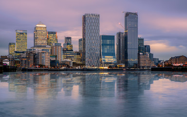 Canary wharf cityscape. The buildings are reflected in Thames river’s water. Canary wharf is the...