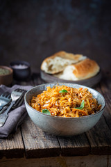 Stewed or braised cabbage served in a bowl on Rustic wooden background, close up