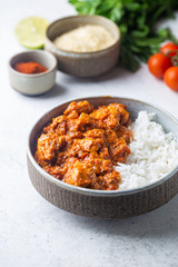 Chicken meat with tikka masala sauce, spicy curry food in a bowl with rice and seasonings