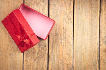 Top view of red gift box on wooden table. Christmas, New Year, Valentine's, Birthday and special occasions concept.