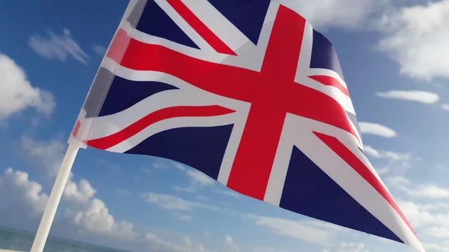 British flag waving by light breeze over tropical beach with a cloudy sky background in Canvey Island