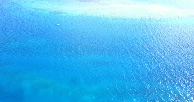 Azure vibrant sea surface surrounding a turquoise area over an new atoll created on last centuries in Palmyra