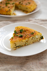 A piece of spaghetti omelette on a white plate, side view. Close-up.