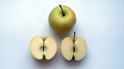 Organic yellow apple  and half sliced apple on white background