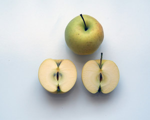 Organic yellow apple  and half sliced apple on white background