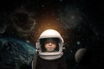 a small child imagines himself to be an astronaut in an astronaut's helmet. © vovan