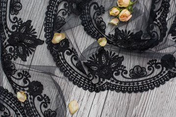 White wooden background with white spring flowers roses and lace ribbon. Happy womans day. The texture of lace on wooden background. Black