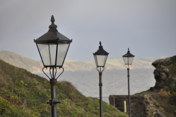 Fototapeta na wymiar 3 old street lamps on cloudy sky