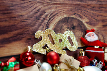 Christmas and happy new year 2020 background with decorations, celebration balls on wooden board