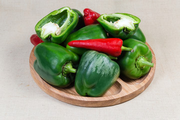Bell peppers on the wooden serving dish on cloth surface