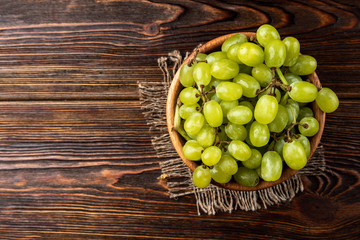 Green grape on dark wooden background.