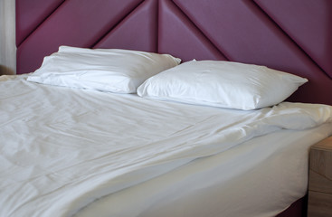 Fototapeta na wymiar Bed white pillows on white bed in bedroom. Hotel service.