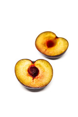 A plum cut into 2 parts on white background