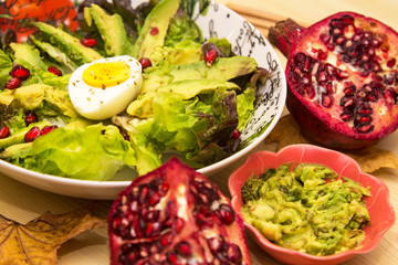 Avocado, egg and pomegranate salad with guacamole, diet and food concept