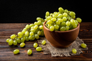 Green grape on dark wooden background.