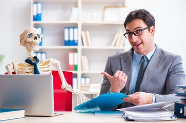 Businessman working with skeleton in office
