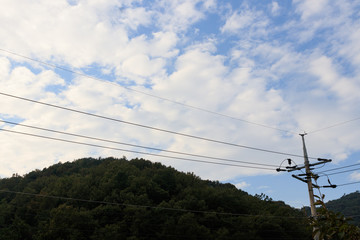 Naju-si, Jeollanam-do / South Korea - OCTOBER 17, 2019:  Utility Pole wiring wires with mountain background
