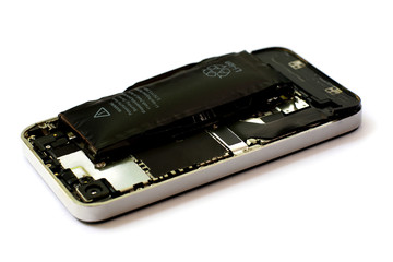 Swollen lithium ion polymer battery inside a mobile phone on white background isolated