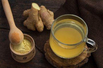 Cup of ginger tea on wooden background
