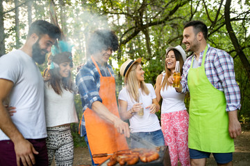 Friends having a barbecue party and fun in nature