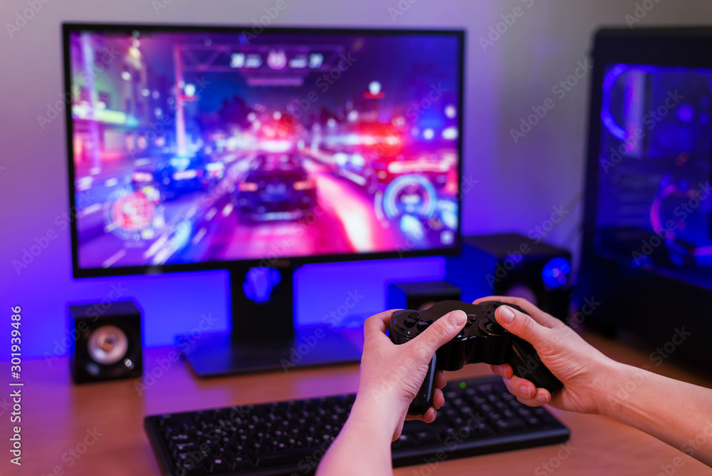 Poster playing racing games on computer concept. hand holds the joystick. in the background is a gaming com