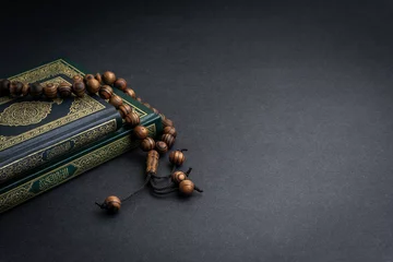 Fotobehang Holy Quran with arabic calligraphy meaning of Al Quran and tasbih or rosary beads on black background. Selective focus and crop fragment © instagram.com/_alfil
