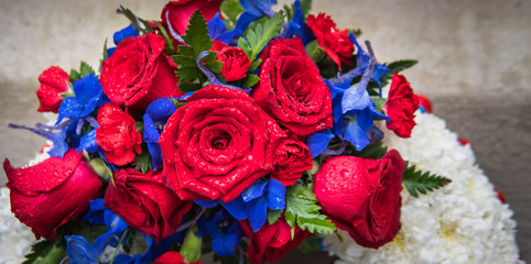 Bouquet of flowers and red roses laying on the stone floor.