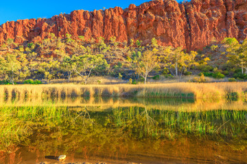 Glen Helen Gorge reflecting on waterhole on Finke River. Tjoritja - West MacDonnell Ranges in Northern Territory, Central Australia. Australian outback along Red Centre Way, 130km of Alice Springs.