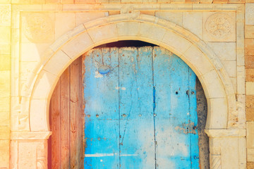 Fototapeta na wymiar Cracked blue door in the house with Arabic ornaments, background. Sidi Bou Said, Tunisia