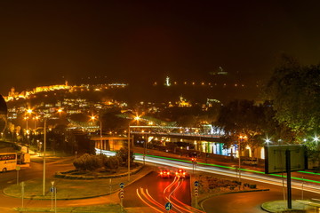 Fototapeta premium Pedestrian Bridge of Peace over the Kura River, Narikala Fortress and Kartlis Deda Monument in Tbilisi, Georgia