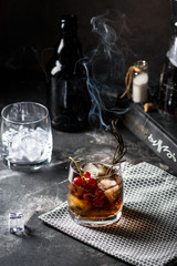 Cuba Libre or long island iced tea cocktail with strong drinks, cola, lime and ice in glass, cold longdrink or lemonade. Cocktail with fire. Cocktail with smoke.