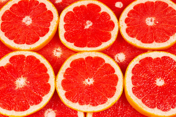 Grapefruit red juicy slices background. top view