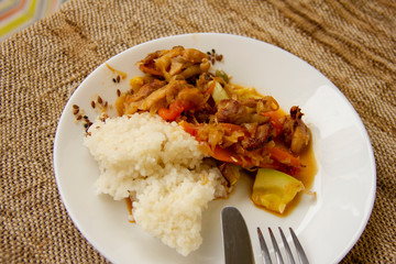 rice and vegetable stew with chicken meat on a white plate. Home cooked food. Asian recipes